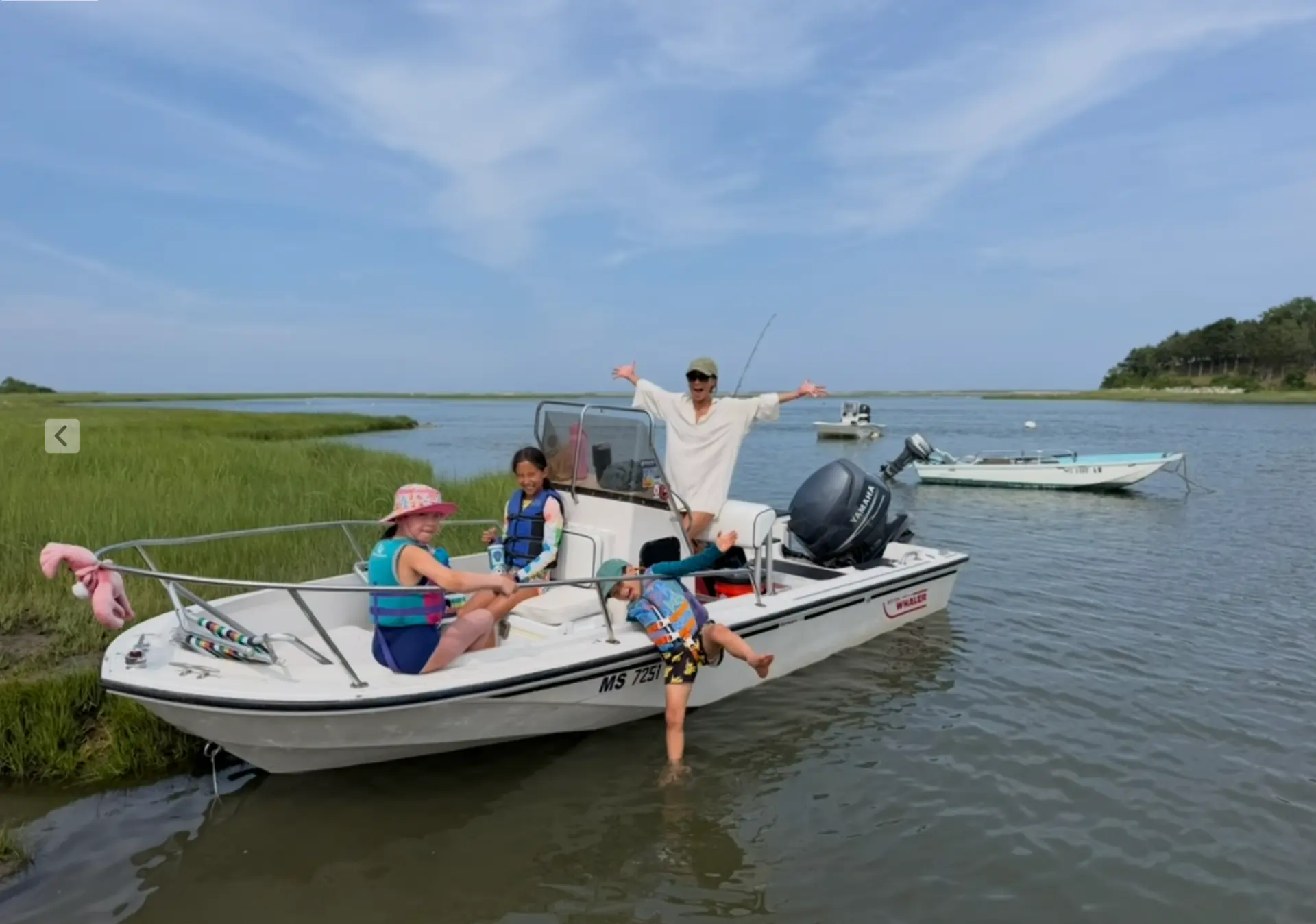 Family on the bow of the boat at low tide on the marsh